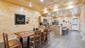 Un interior de madera con comedor, cocina y una puerta.