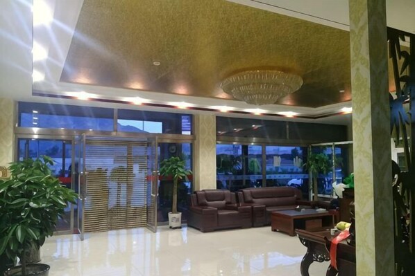 A lobby with a reception desk, seating area, large windows, and a chandelier. - Hunyuan Haoya Express Hotel (Hunyuan)