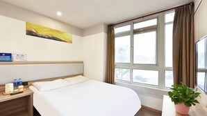 A hotel room with a bed, bedside table, a potted plant, a window with curtains, and a painting on the wall. - Homeinn Pebble Hotel (Beijing Tongren Hospital Chongwenmen Subway Station) (Beijing)
