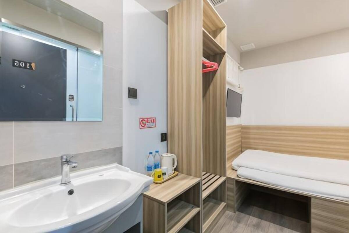 Une salle de bain moderne avec un lavabo, un miroir et un meuble de rangement en bois.