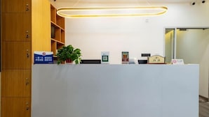 Una reception con una pianta, un cartello e un quadro incorniciato.