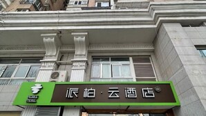 Segnaletica di un hotel con una combinazione di colori verde e marrone, che presenta un logo e del testo in lingua straniera.