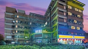 A multi-story hotel with a green sign reading "Spring Hotel MINI 4F". - Qingji Hotel MINI (Shanghai Overseas Gaoqiao Guangming Road Branch) (Shanghai)