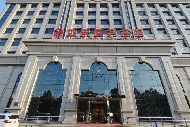 A multi-story building with a large entrance and reflective glass windows.