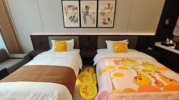 A hotel room with two beds, a sofa, and artwork on the wall.