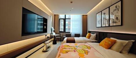Ein modernes Hotelzimmer mit einem großen Bett, einem Flachbildfernseher, einem Schreibtisch mit Stuhl und Kunstwerken an den Wänden.