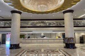 A hotel lobby with a reception desk, marble flooring, and a large chandelier. - Beijing Jindilai Business Club (Yansai Outlets Miyun Branch) (Beijing)