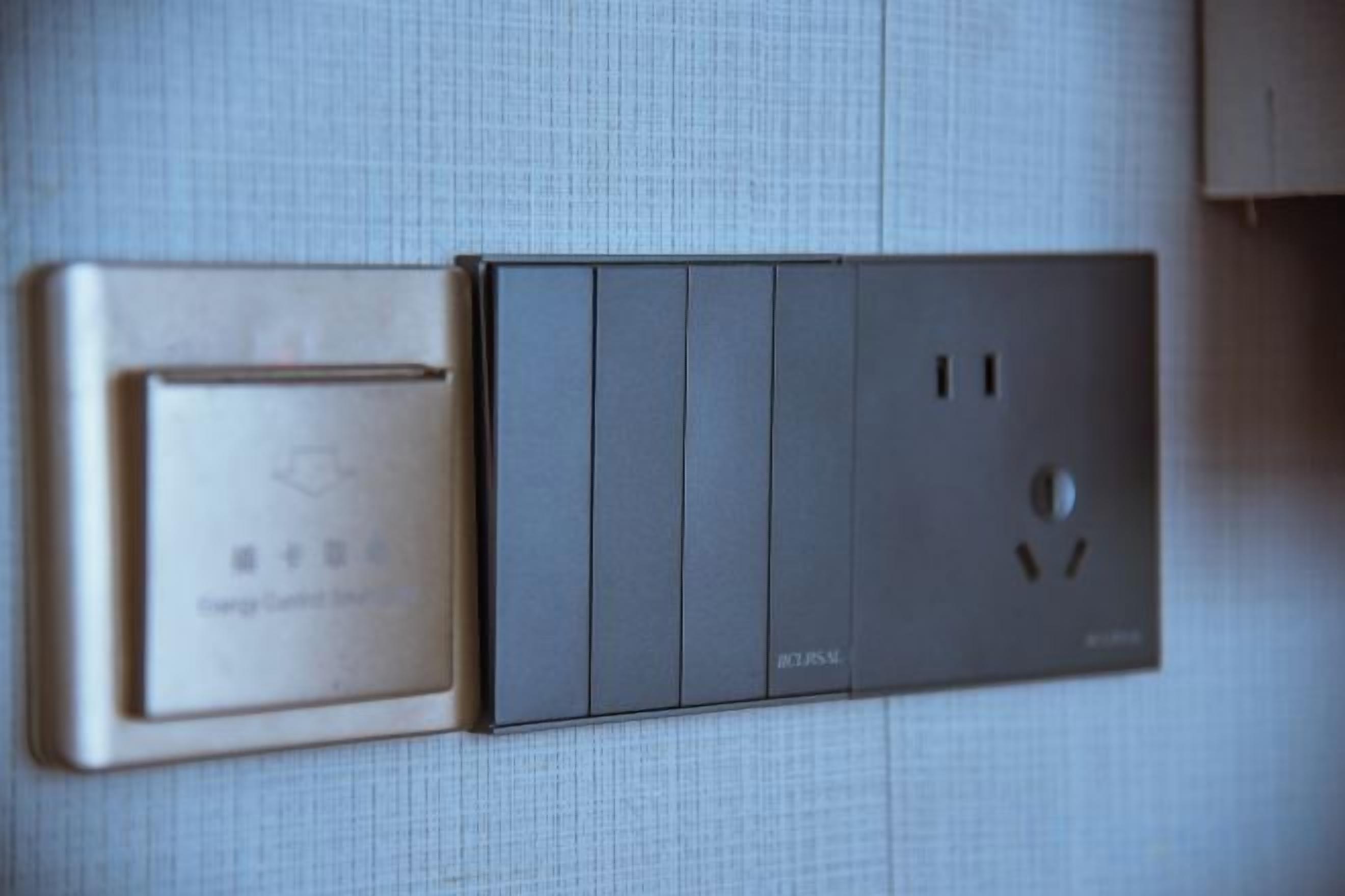 Une prise électrique murale dotée d’un interrupteur et d’une prise.