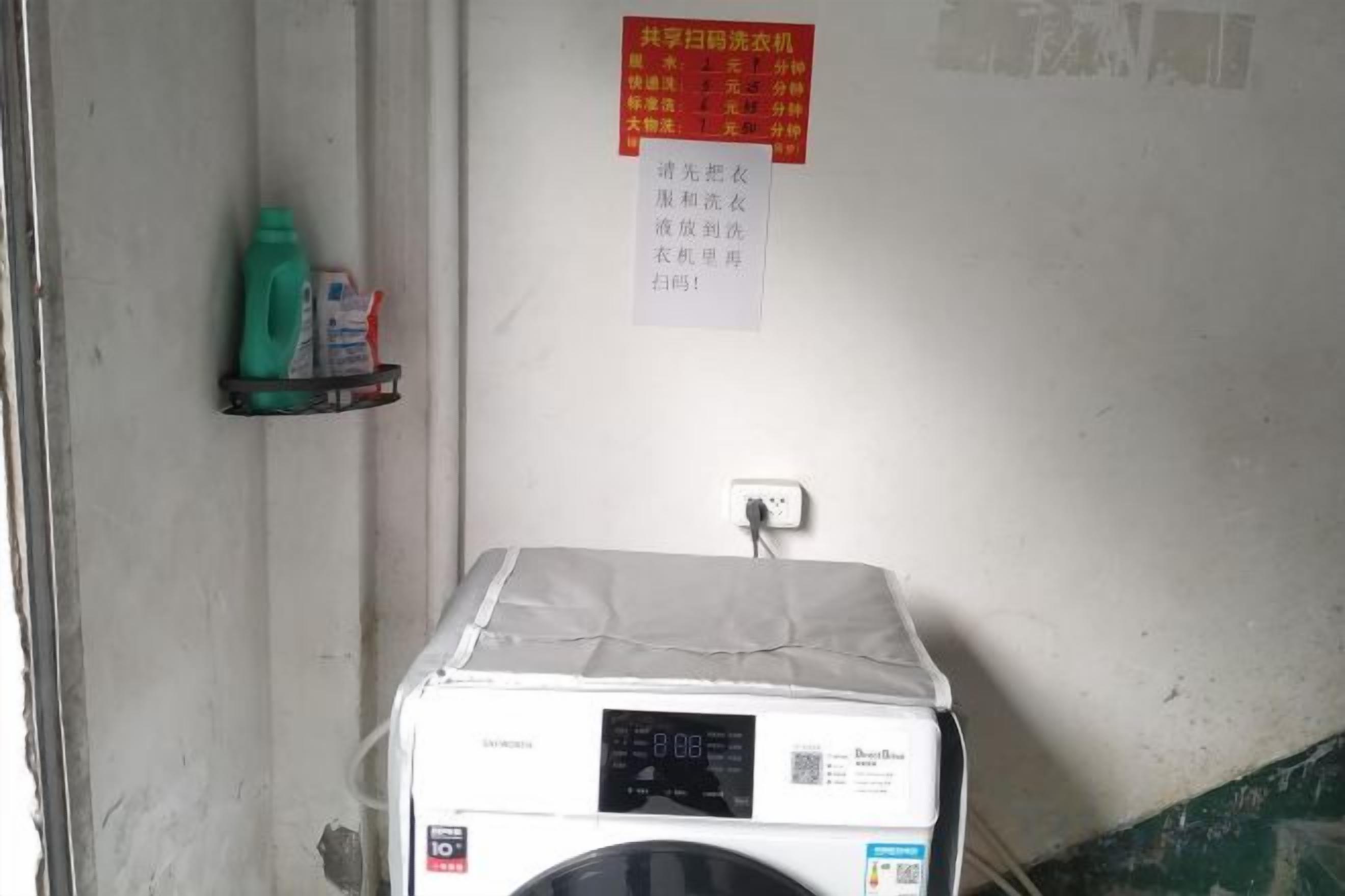 A room with a washing machine, a shelf with cleaning supplies, and a wall with a notice.