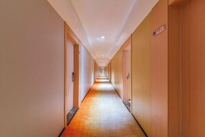 A long, narrow hotel corridor with doors on both sides, a wooden floor, and a sign indicating room number 8229. - Qiu shan Hotel (Wenzhou)