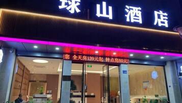 A hotel entrance with a sign that reads '珠山酒店' and a price tag indicating '全天房 139元起'.
