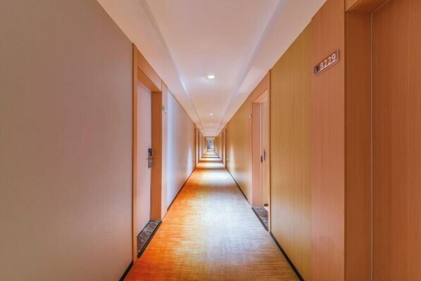 A long, narrow hotel corridor with wooden walls and a carpeted floor. - Qiu shan Hotel (Wenzhou)