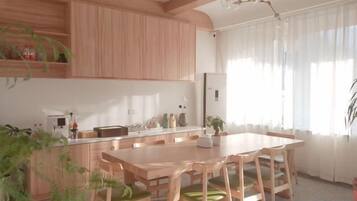 Una cocina moderna con armarios de madera, una isla central y una zona de comedor con mesa y sillas.