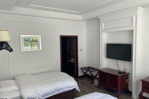 Une chambre d’hôtel avec un lit, une télévision, un bureau et une chaise.