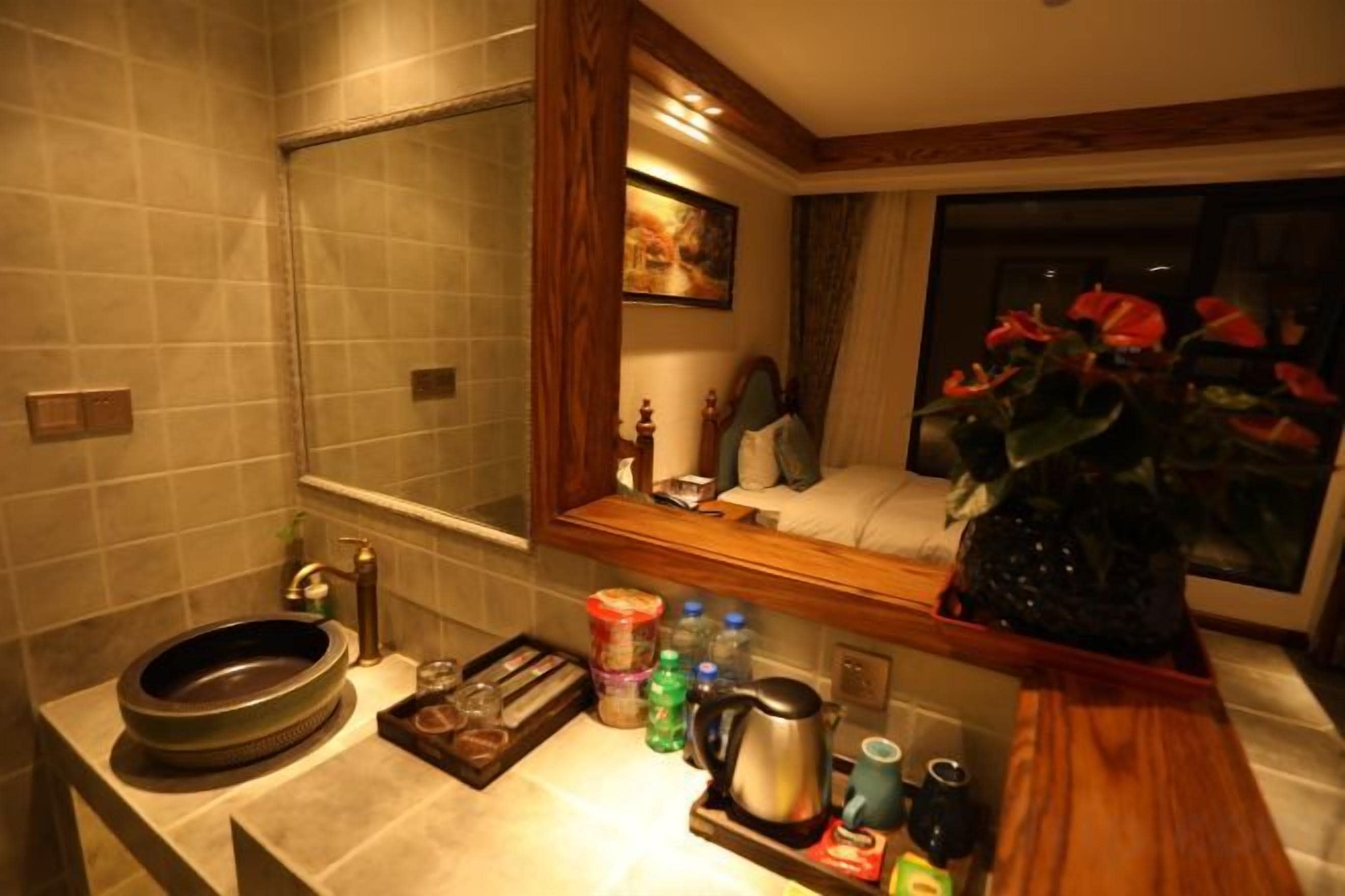 A bathroom with a sink, mirror, and a window with a view of the night sky.