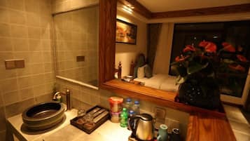 A bathroom with a sink, mirror, and a window with a view of the night sky.