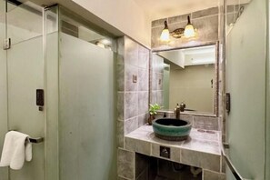 A bathroom with a glass shower enclosure, a sink with a round basin, and a mirror with wall-mounted lights. - Jiamei Tianyuan Hotel (Shanghai)