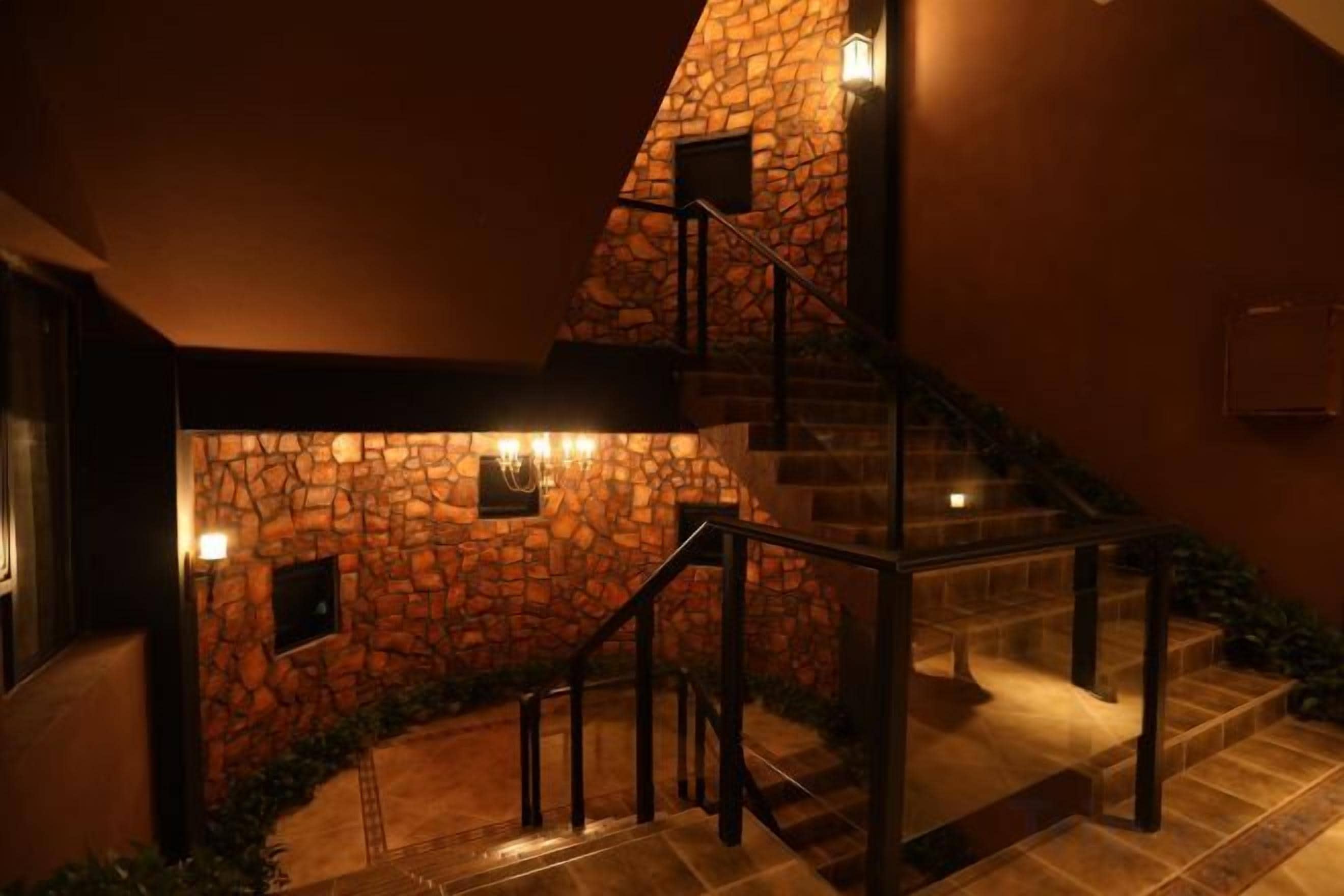 A staircase with stone walls and metal railings, leading to an upper level.