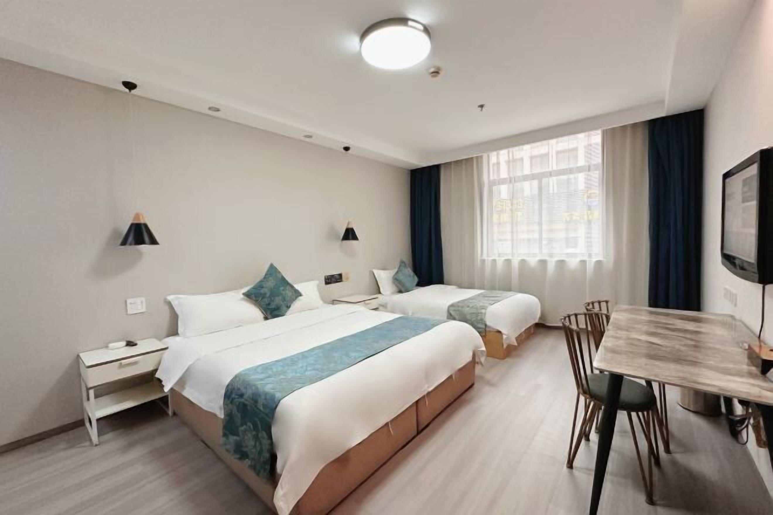 Une chambre d’hôtel avec deux lits, une table à manger et un téléviseur.