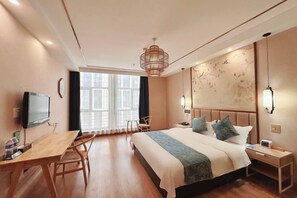 A hotel room with a bed, desk, chair, television, and a large window. - Jingan Hotel (Shaoxing Keqiao Yintai Lantian Shixin Plaza) (Shaoxing)