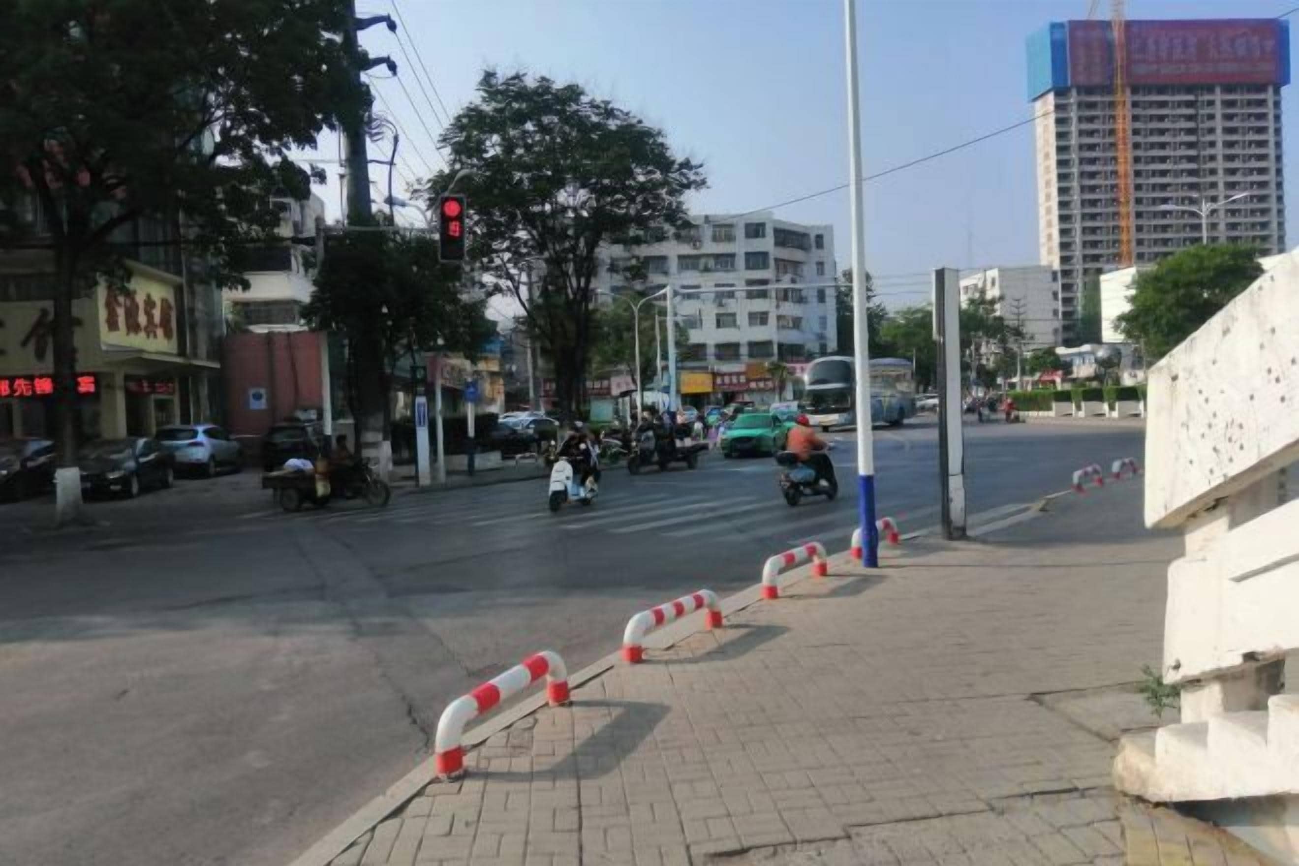 Een straatkruising met verkeerslichten, voertuigen en een zebrapad.