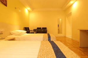 Een hotelkamer met twee bedden, een bureau, een stoel en een spiegel.