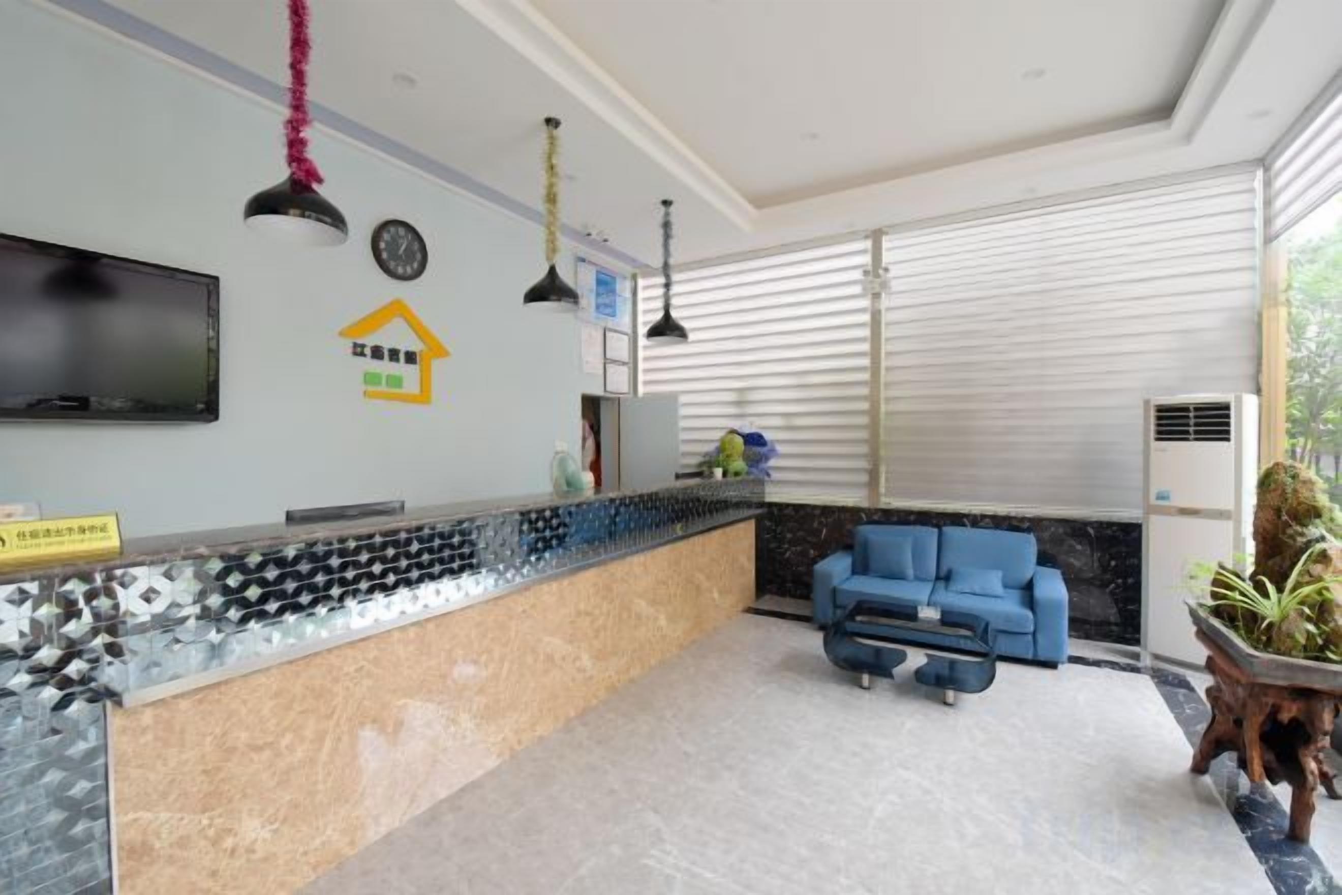 Un área de recepción con mostrador, asientos y una televisión.