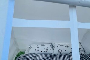 A white room with a bed, checkered bedding, and smiley face pillows. - Baoxing Shenmu Lei Mountain Villa (Baoxing)