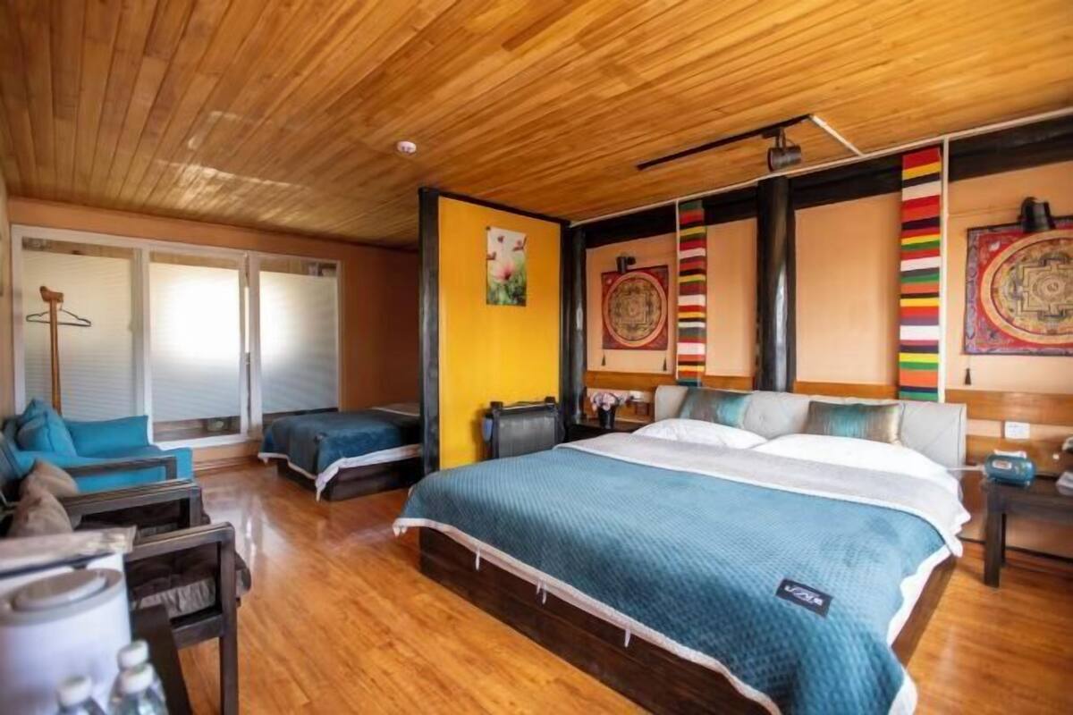 A bedroom with a large bed, a wooden ceiling, and a sliding glass door leading to a balcony.