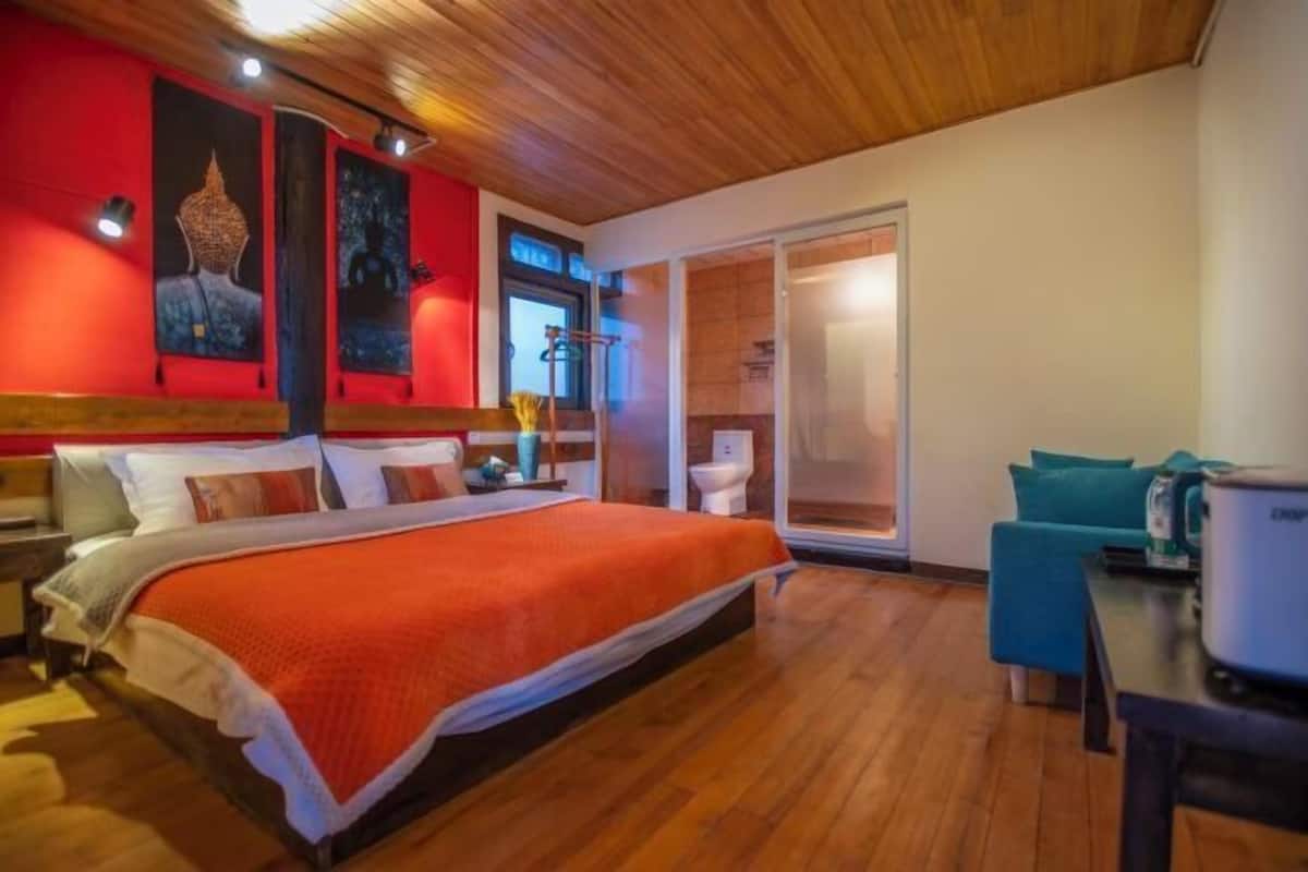 A bedroom with a bed, a desk, and a chair.