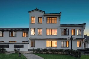 A multi-story residential building with a symmetrical facade, large windows, and a well-maintained lawn. - Shanghai Duoyun Xianjuju B&B (Fengxian Wufangcun Branch) (Shanghai)