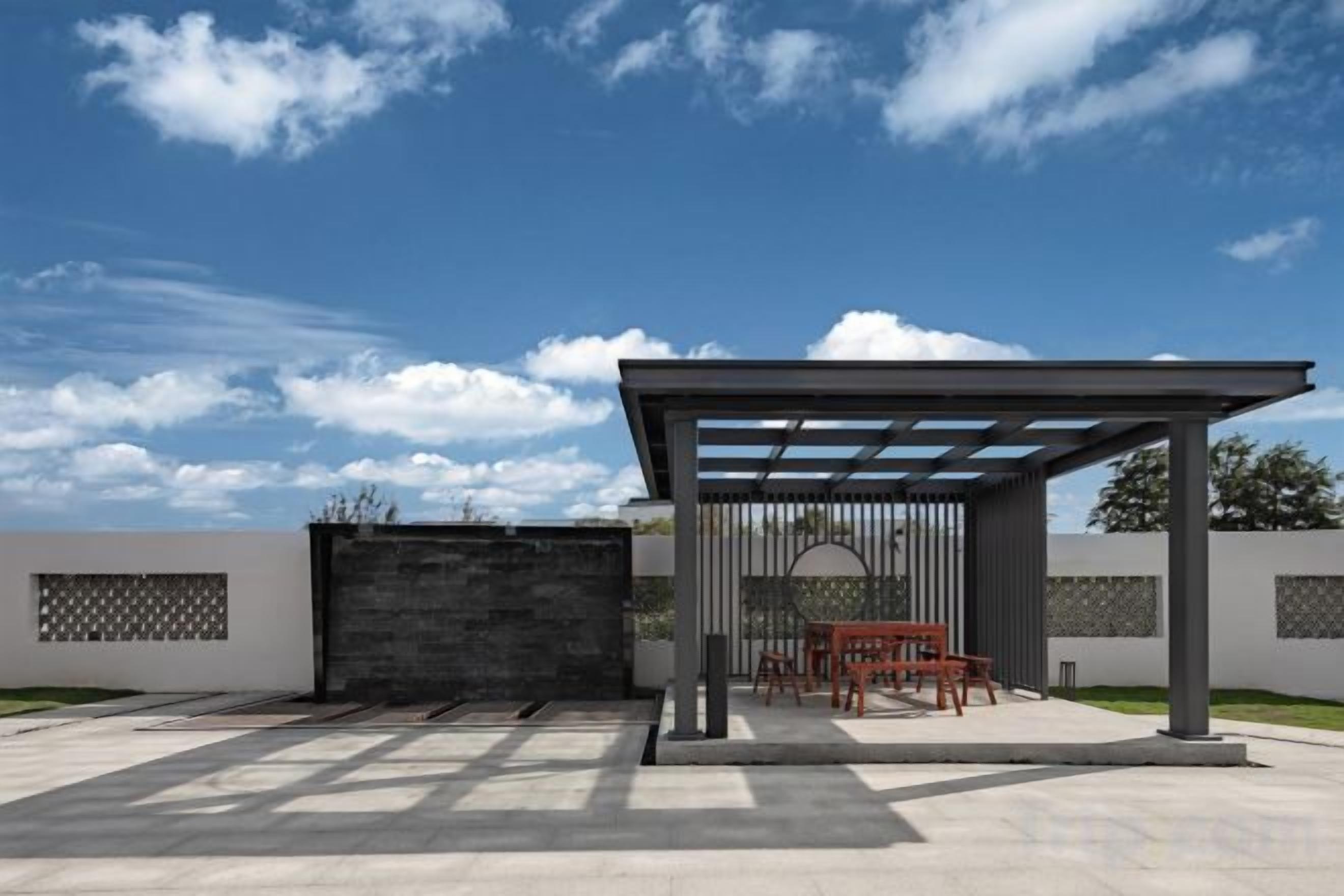 An outdoor patio with a pergola, seating, and a gate.