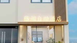 Ein Hotel Eingang mit modernem Design, erkennbar an einer auffälligen Beschilderung mit chinesischen Schriftzeichen.