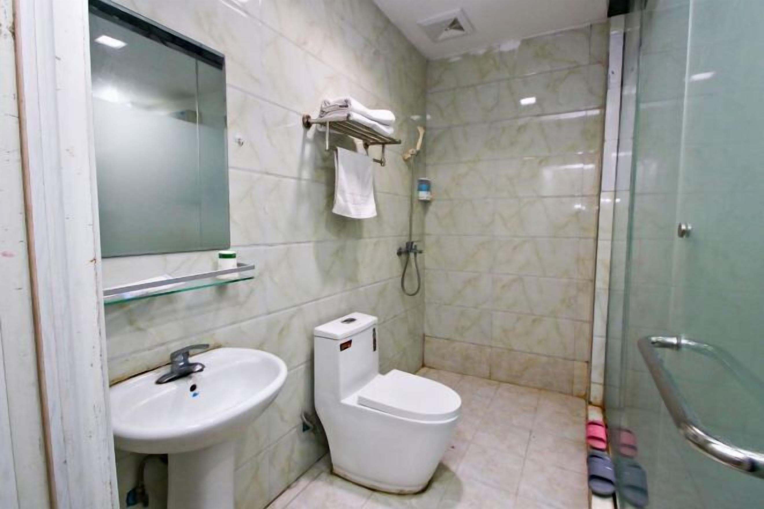 A bathroom with a sink, toilet, and glass shower enclosure.