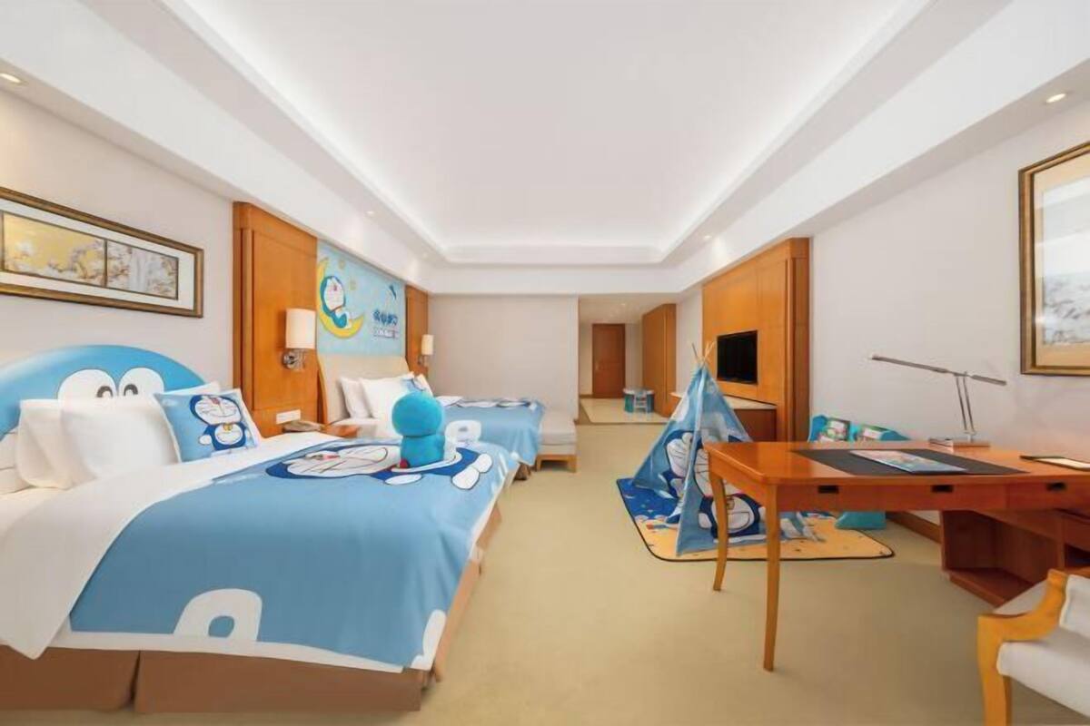 Una habitación de hotel con dos camas, un escritorio y una silla.