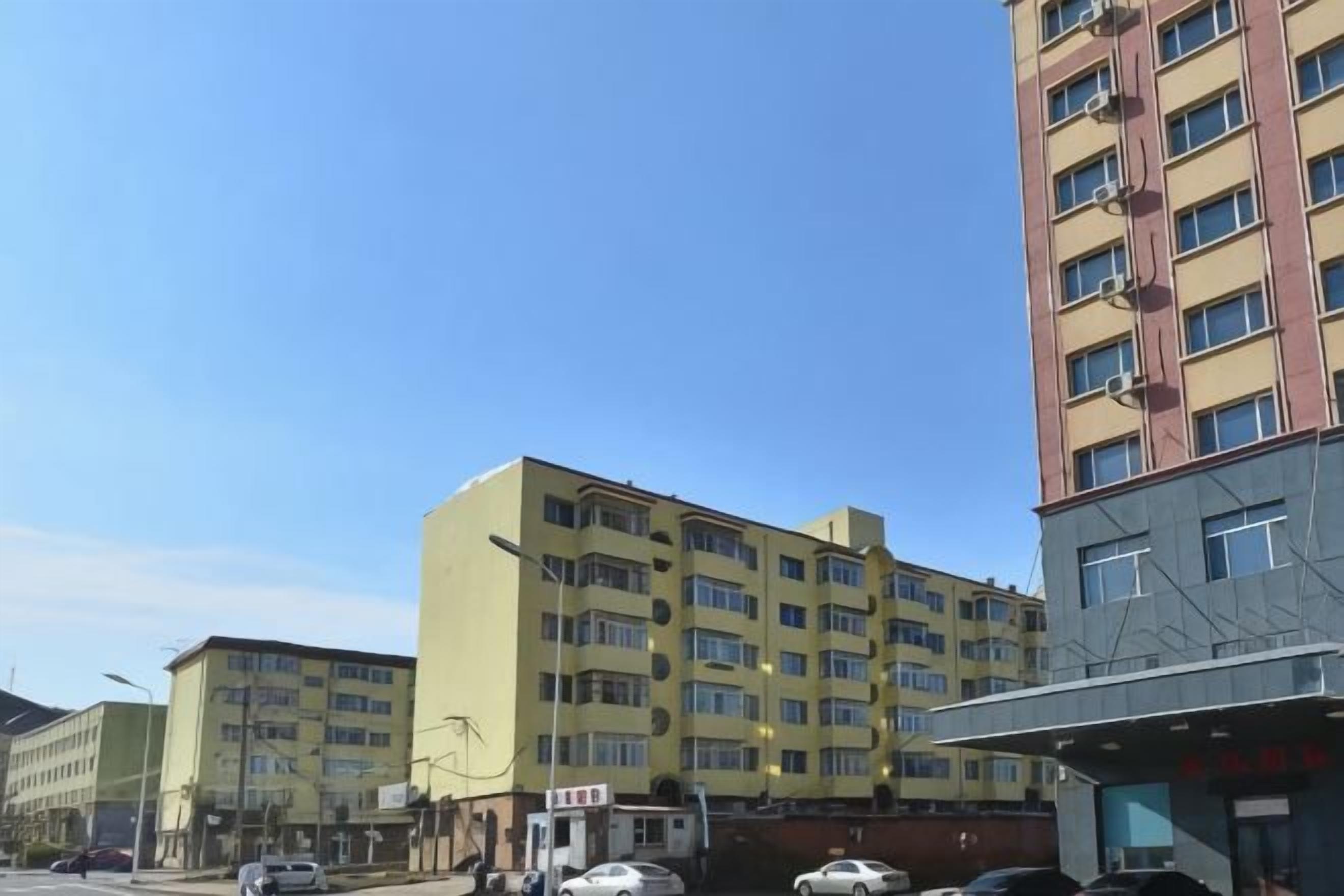 Un immeuble à plusieurs étages, doté d’une façade plane, de nombreuses fenêtres et d’une entrée bien visible.