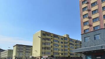 A multi-story building with a flat facade, several windows, and a visible entrance.