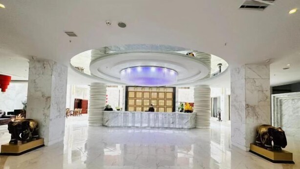 A spacious lobby with a marble floor, a reception desk, and a circular ceiling design. - Fuyuan Yayue Business Hotel (Fuyuan)