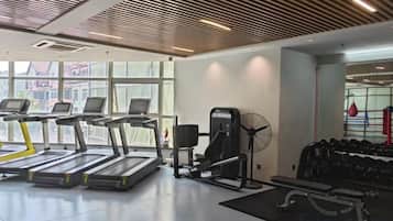 A gym with treadmills, weight machines, and a fan.