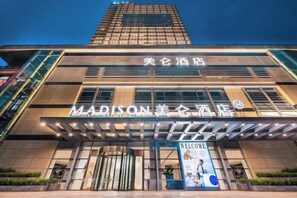 A hotel with a modern facade, a prominent entrance, and signage indicating it is the Madison Hotel. - Madison Hotel Qingdao City Center (May Fourth Square) (Qingdao)