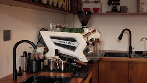 A kitchen with a coffee machine, sink, and various utensils. - Dali Nuan Nuan Ying Jing Cliff Sea View Hotel (Dali City)