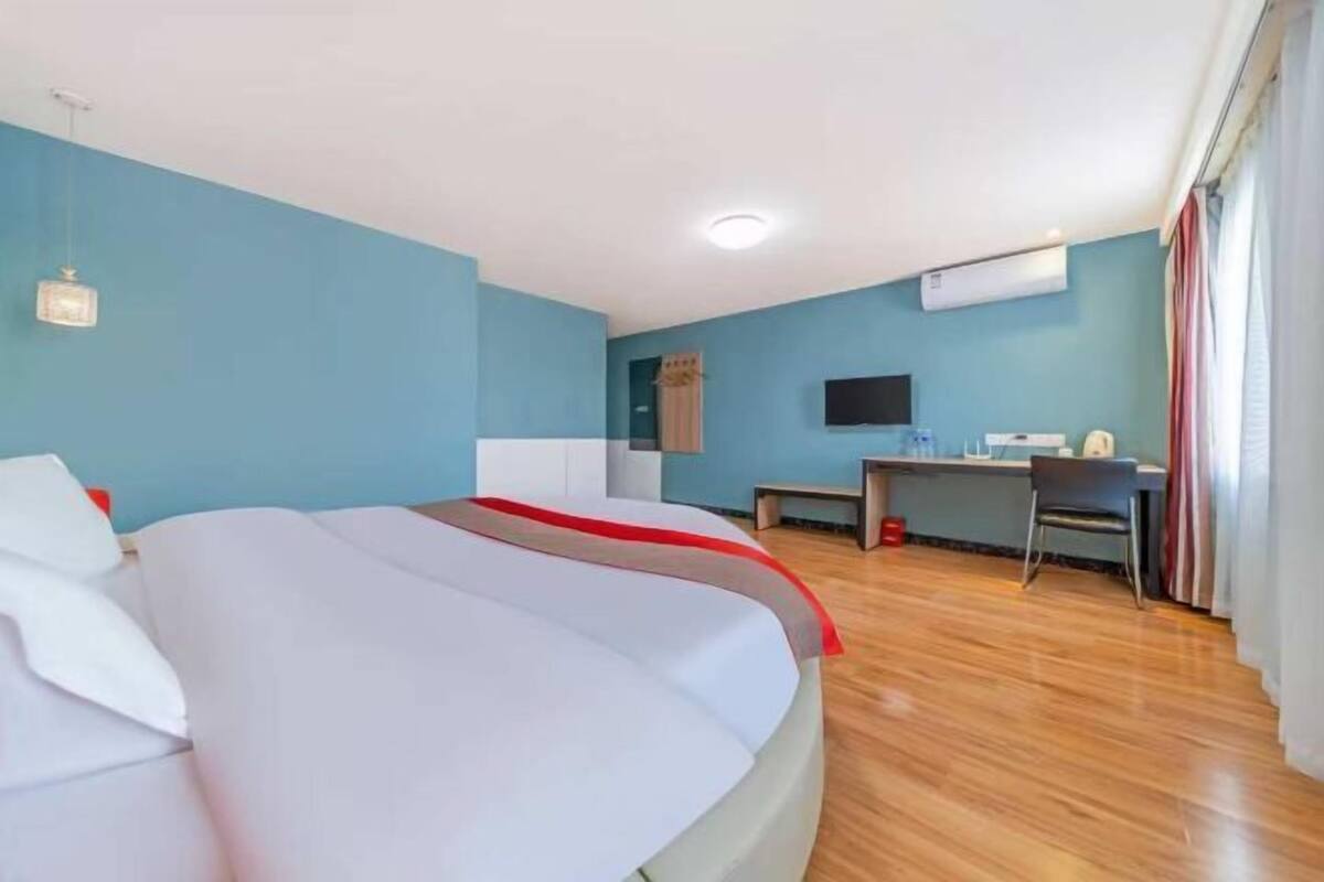 Una habitación de hotel con una cama, un escritorio y un televisor.