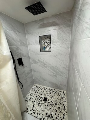 Chuveiro, secador de cabelo, toalhas de banho, papel higiênico