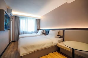 A hotel room with two beds, a small round table, and a wall-mounted air conditioning unit. - HanTing Hotel (Tianjin Railway Station Italian Style Street) (Tianjin)