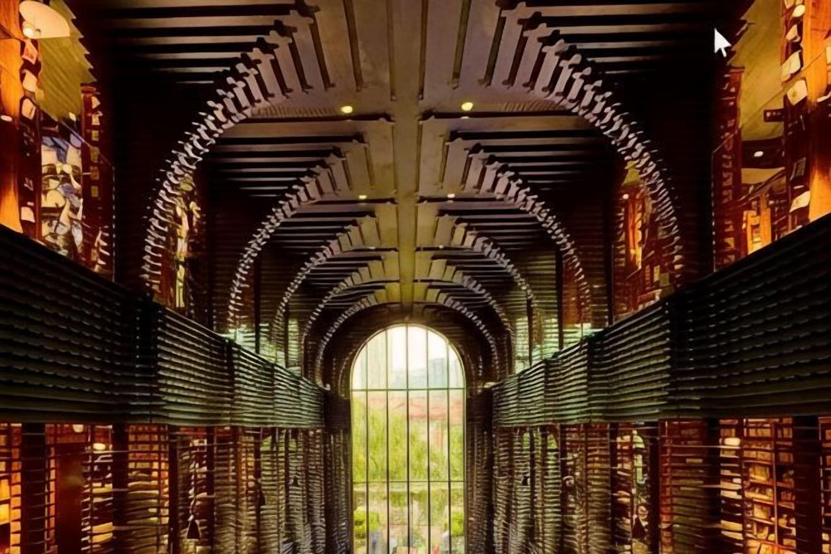 L’intérieur d’une bibliothèque, avec des voûtes en arc et des étagères à livres.