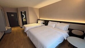 A hotel room with two beds, a small table, and a mirror. - HanTing Hotel (Tianjin Railway Station Italian Style Street) (Tianjin)