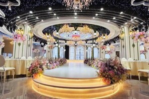 A grand hall with a central stage, ornate chandeliers, and floral arrangements. - Fugang Hotel(Xuchang College High Speed Rail East Station Store) (Xuchang)