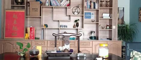 A traditional kitchen with wooden cabinets, a dining table, and various kitchen items.