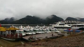 Un puerto deportivo con barcos amarrados, un muelle y montañas al fondo.
