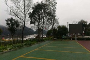 A parking area with green and yellow markings, surrounded by trees and a view of mountains. - Taining Dajinhu Xiuzhen Homestay (Taining)